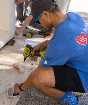 PlayStation employee shown using a drill to build something for a community volunteering event for PS Cares.