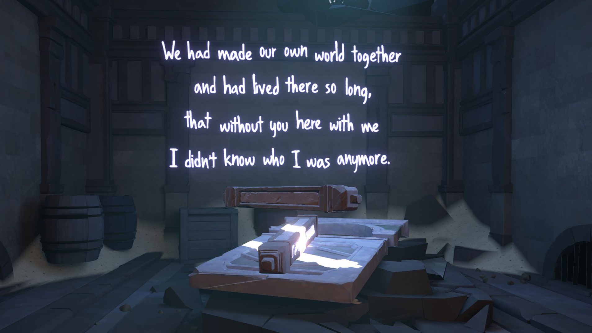 A dark room is pictured with a beam of light shining diagonally across a flat table. Illuminated white neon text is show against a wall. It reads "We had made our own world together and had lived there so long, that without you here with me I didn't know who i was anymore."