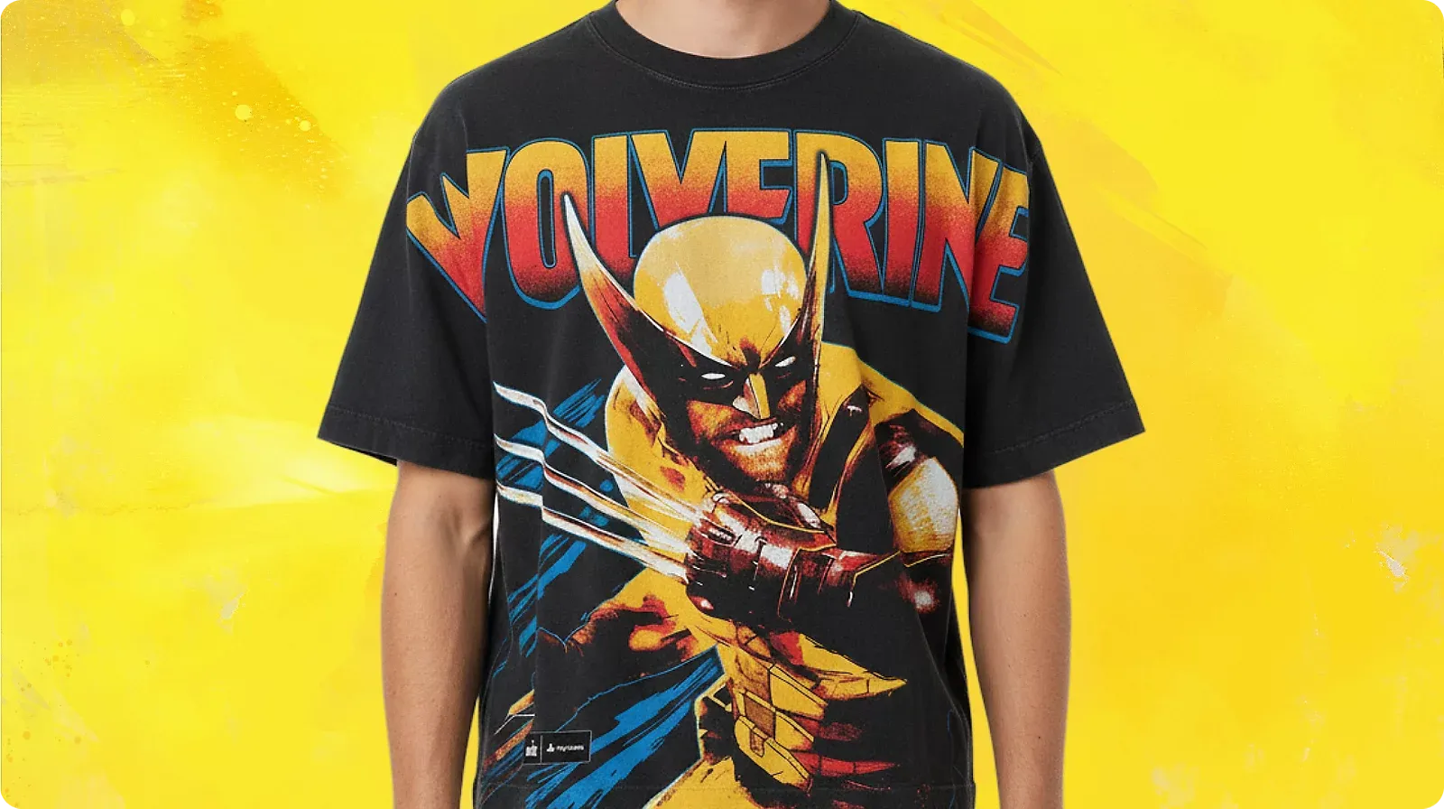 Model wearing a black t-shirt featuring Wolverine in a yellow suit with claws extended, topped with "Wolverine" in a red-and-yellow gradient retro logo.