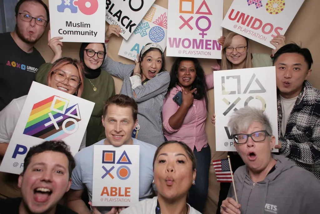 各社員ネットワークのロゴを掲げるSIE社員の集合写真