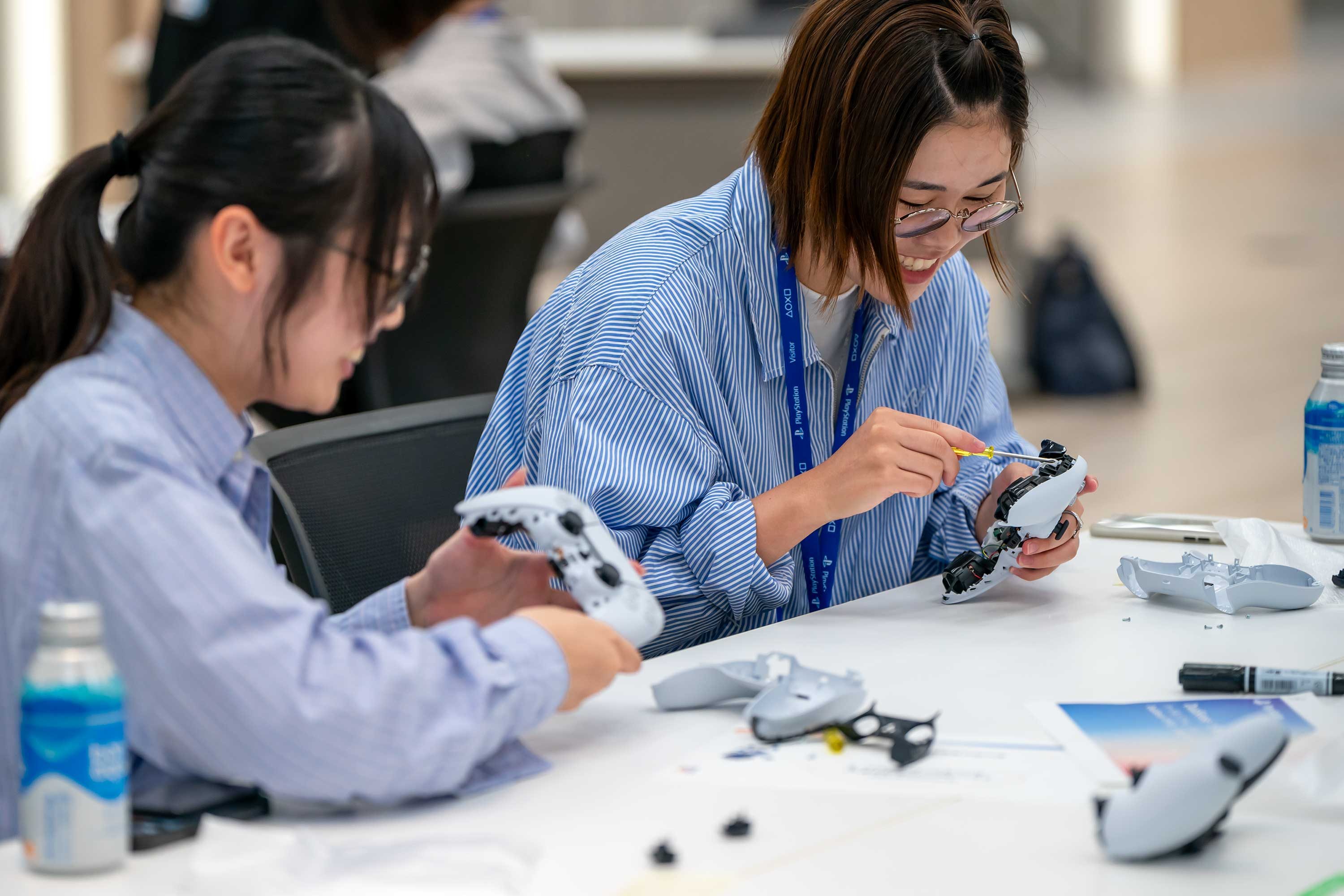 SIEエンジニアを目指す女子学生向けオープン・カンパニーイベントの参加者がDualSenseコントローラーを分解している