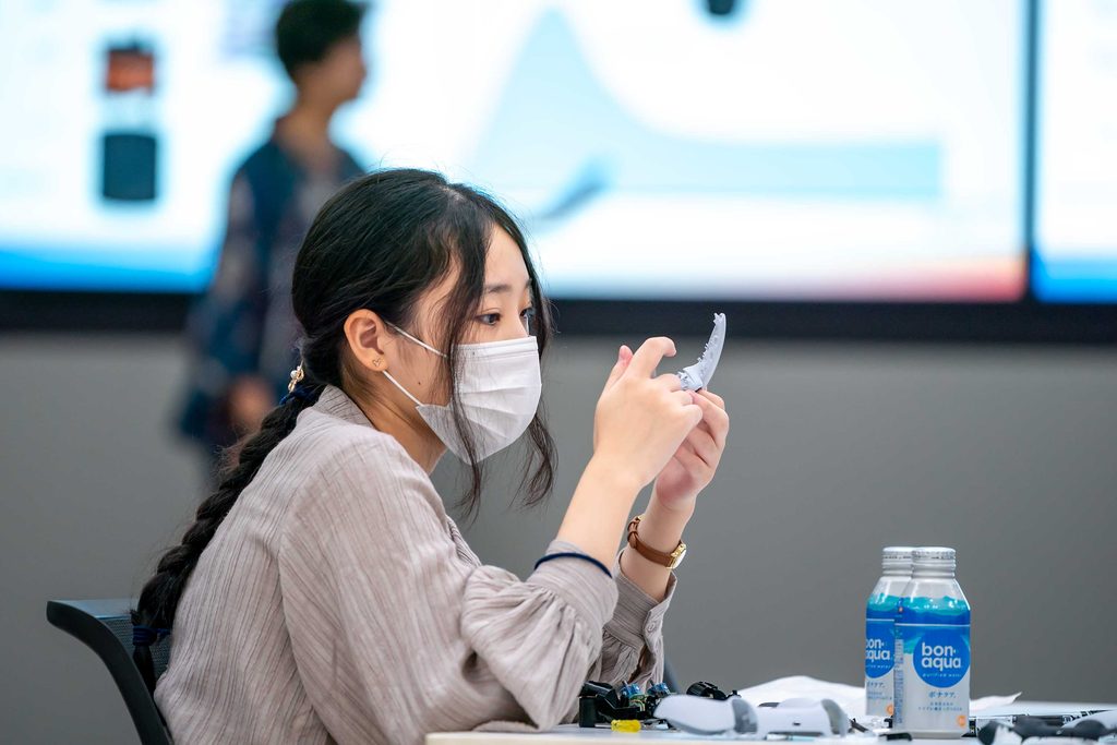 SIEエンジニアを目指す女子学生向けオープン・カンパニーイベントの参加者がDualSenseコントローラーを分解している