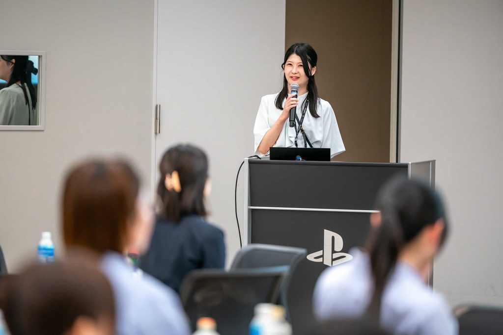 SIEエンジニアを目指す女子学生向けオープン・カンパニーイベントで参加者向けに仕事内容について紹介する女性エンジニア