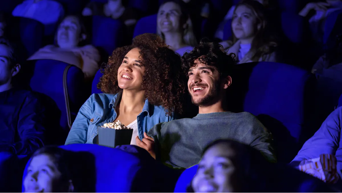 Couple watching a movie at the Alamo Drafthouse movie theater.